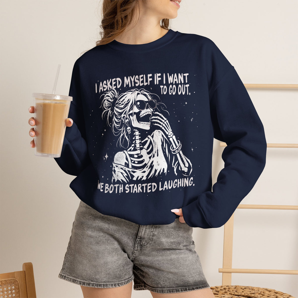 Lifestyle mockup of the I Asked Myself If I'm Going to Behave, We Both Started Laughing skeleton Gildan 18000 sweatshirt.