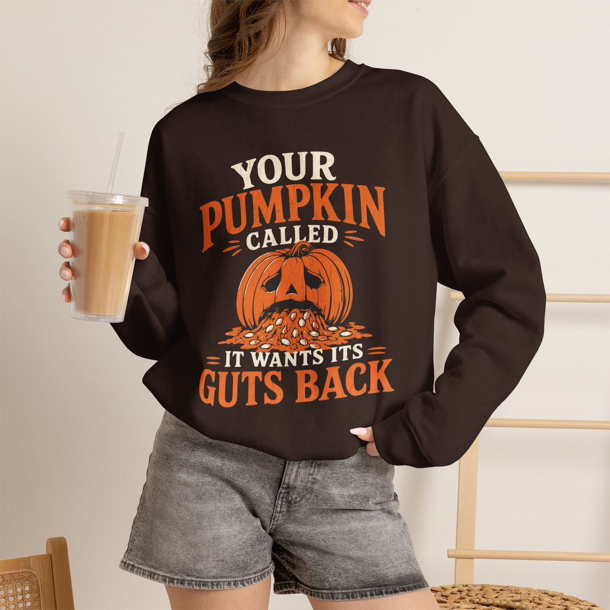Lifestyle mockup of the Your Pumpkin Called It Wants Its Guts Back Gildan 18000 sweatshirt.