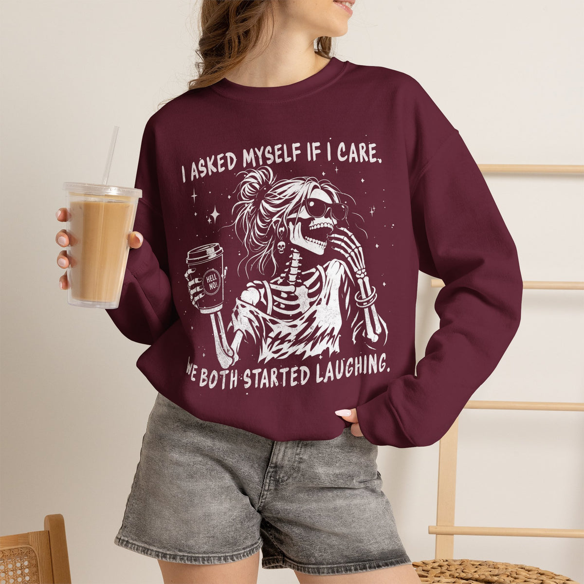 Maroon Gildan 18000 sweatshirt with laughing messy-bun skeleton graphic and sarcastic behave quote.
